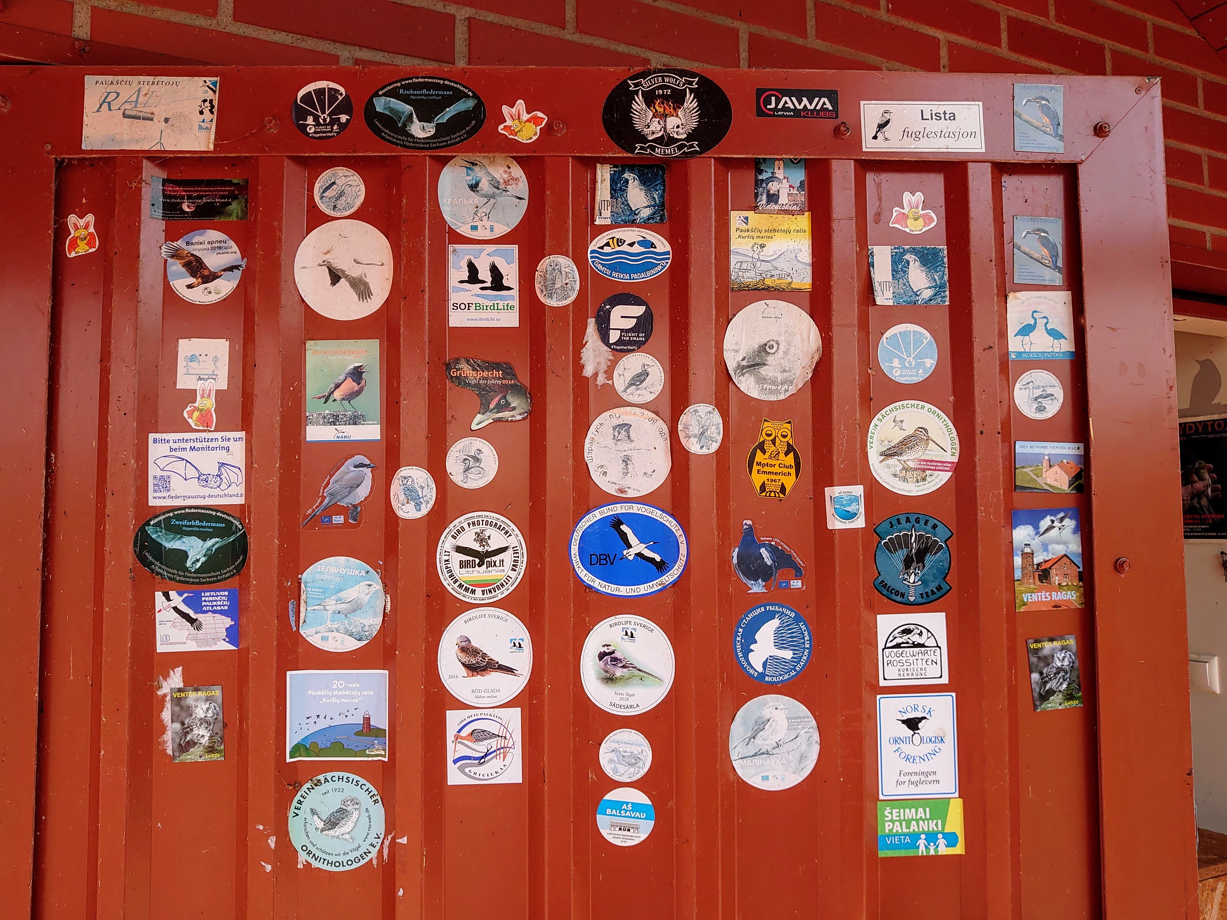 A door at the Ventė Cape Ornithological  Station with stickers pasted on it by many birders who have visited.